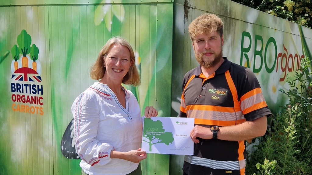 Lucy MacLennan presents the Young Organic Farmer/Grower of the Year award to last year's winner Alex Parkinson of RBOrganic