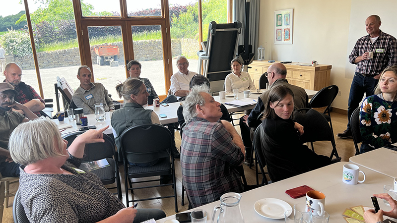 A room of people engaging in discussion with Jonty Bronyee