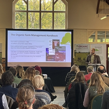 Rowan speaking to Organic Farm Management Handbook slide in packed hall