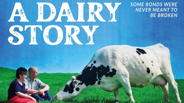 Cover pic for film with Wilma and David sat on the ground with a dairy cow grazing in front of them