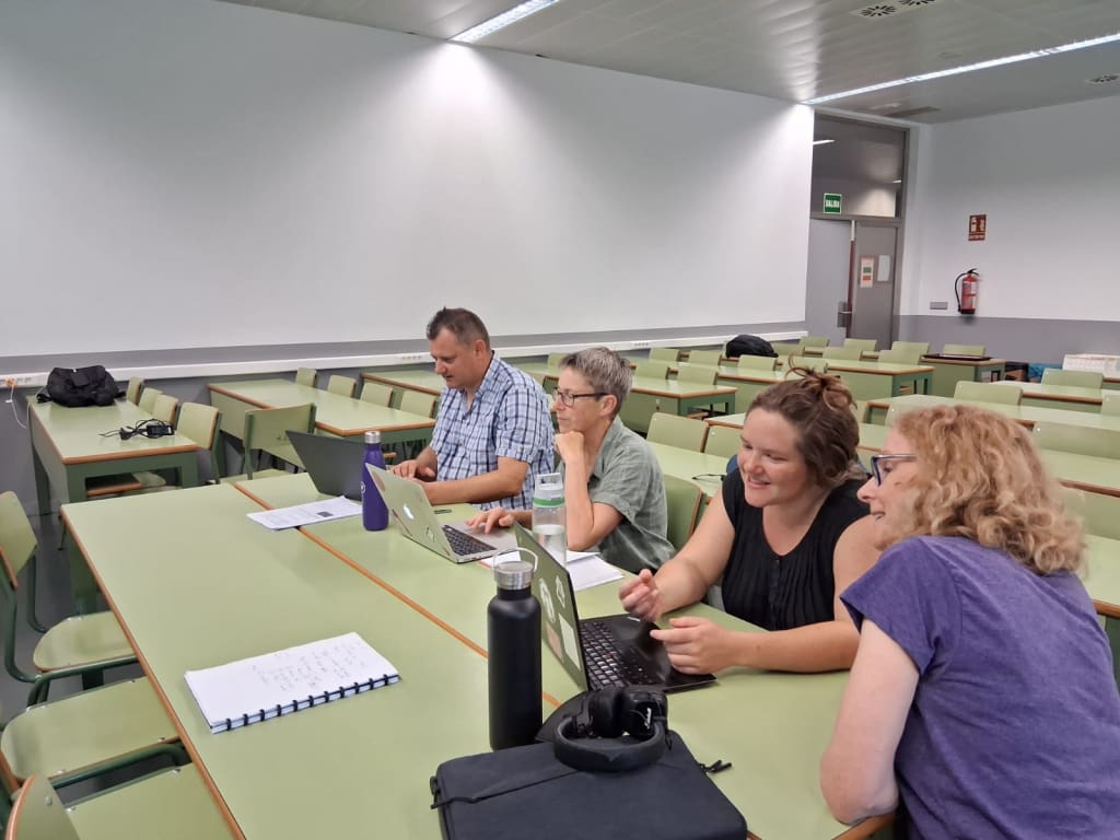 A small group of 4 people in a classroom